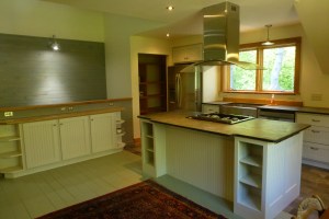 The Roost has a custom kitchen with gas range on an island, farm sink, and all new appliances.